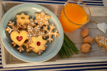 Christmas breakfast on wooden tray, fresh orange juice gingergread, shortcrust pastry cookies and pour feliciter pig 2020