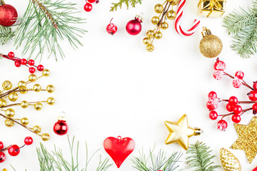 Frame made of Christmas decorations. Red holly berries, gold star and green fir twig composition on white background. Xmas flat lay top view