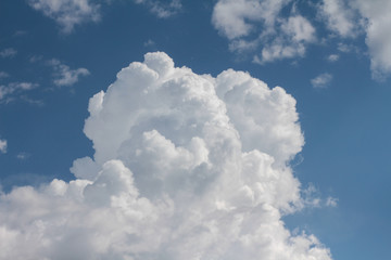 Naklejka na ściany i meble Large cumulus cloud in the dark blue sky. Close-up. 