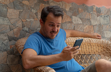 Young guy looking cellphone worried reading the news and having feeling of doubt and confused....