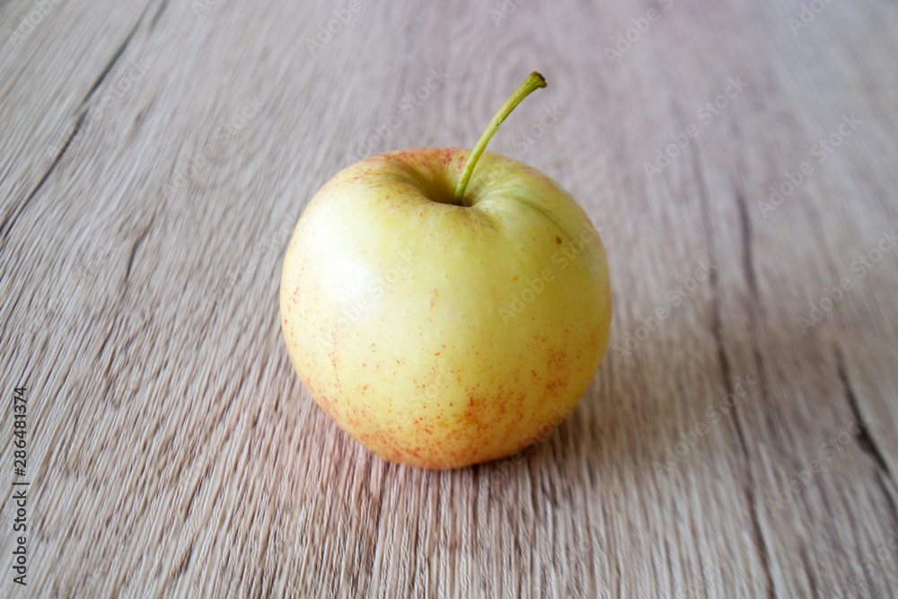 Wall mural close up red apple isolated on wood background