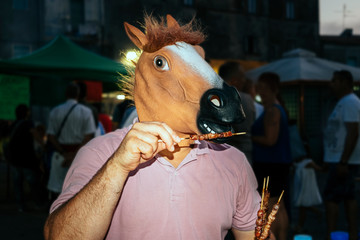 horse-man eating tasty bbq meat at a village festival in the evening