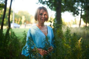 woman in a bush of wild hemp in nature