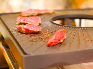 close up of a raclette with raw beef 