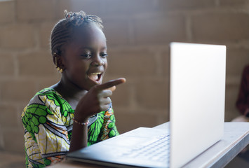Adorable African Little Girl Surprised Looking at Laptop Computer Technology