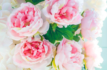 Fototapeta na wymiar Flower arrangement of artificial pink peonies. It can be used as a backdrop.