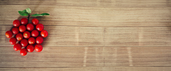 Group of sherry tomatoes forming a single tomato shape on a wooden background with copy space. Selective focus