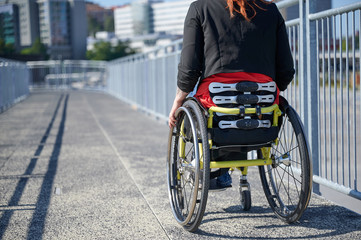 Young woman in wheelchair on a bridge