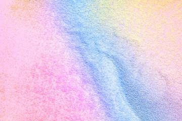 Many multi-colored spangles are scattered on a pink background.  View from above.  Place for text.