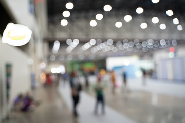 Blurred images of trade fairs in the big hall. image of people walking on a trade fair exhibition...