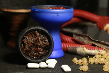 bowl with tobacco for hookah. fruits on a black background