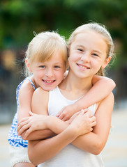 Two smiling little girls embracing
