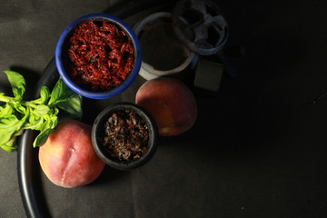 bowl with tobacco for hookah. fruits on a black background