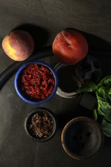 bowl with tobacco for hookah. fruits on a black background. smoke hookah