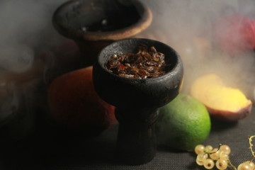 bowl with tobacco for hookah. fruits on a black background