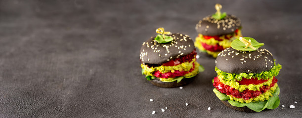 Vegan black burgers with beet patties on dark background