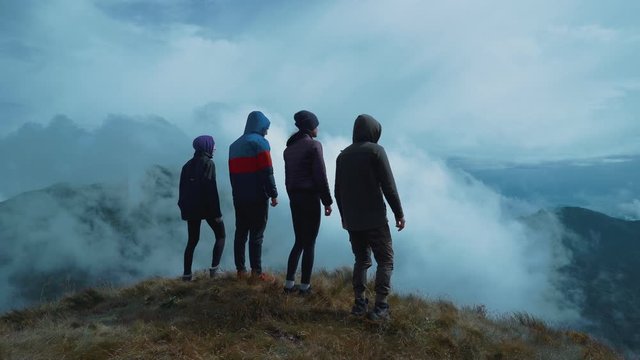 The four people standing on a picturesque mountain