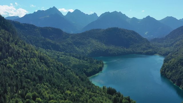 Aerial view of Bavarian Alps mountains in summer, deep waters of picturesque lake Alpsee - landscape panorama of Bavaria from above, Germany, Europe