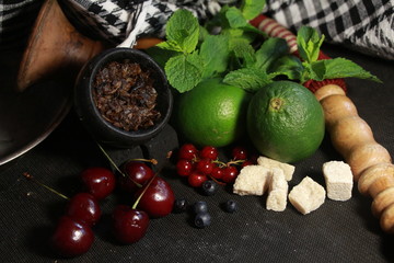 bowl with tobacco for hookah. fruits on a black background. smoke hookah