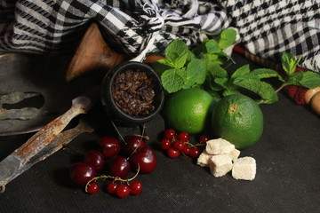 bowl with hookah tobacco. berries on a black background. nargile smoking