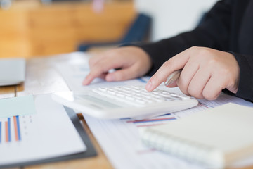Data analysis, Financial accountants are evaluating company revenue data using calculators and databases to compute and summarize for leaders, Young women working.