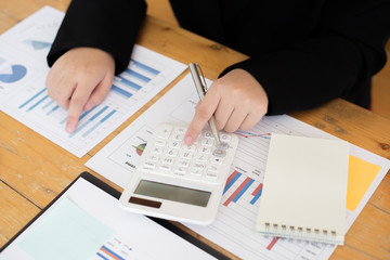 Data analysis, Financial accountants are evaluating company revenue data using calculators and databases to compute and summarize for leaders, Young women working.