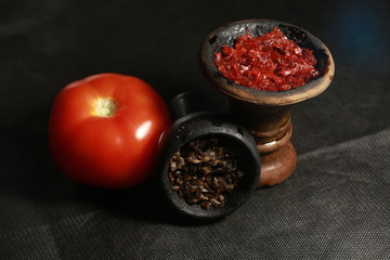 bowl with tobacco for hookah. fruits on a black background