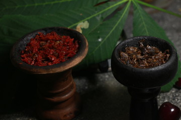 bowl with tobacco for hookah. berries on a black background. smoking sheesha