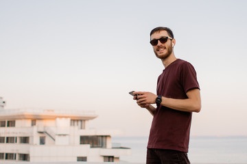 Young man looking at news and messaging on his smart phone.