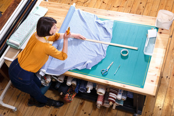 Above view of saleswoman measuring fabric