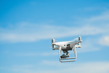 drone quadcopter with digital camera on blue sky background.