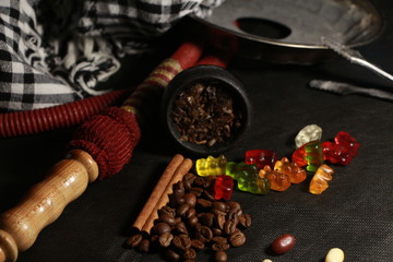 bowl with tobacco for hookah. fruits on a black background. smoke hookah