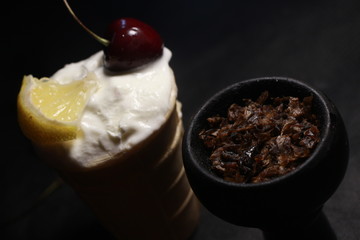 bowl with tobacco for hookah. fruits on a black background