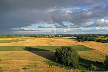 Summer end evening farmland landscape with rainbow, aerial