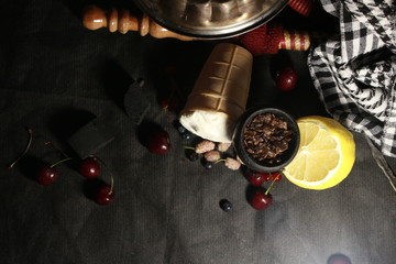 bowl with tobacco for hookah. berries on a black background