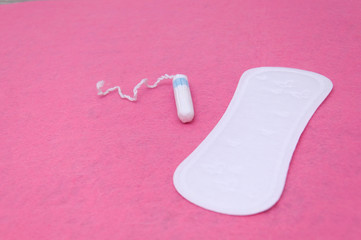 Female pads and tampon close-up on a pink background. Women's critical days.
