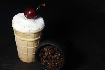 bowl with tobacco for hookah. berries on a black background