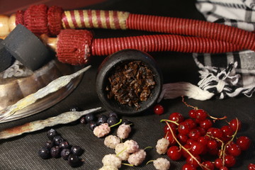 bowl with tobacco for hookah. berries on a black background. smoking sheesha