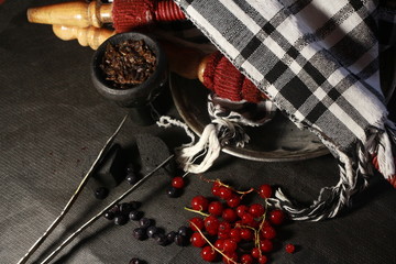 bowl with tobacco for hookah. fruits on a black background. smoke hookah
