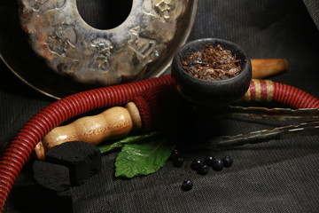 bowl with tobacco for hookah. fruits on a black background. smoke hookah
