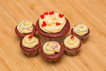 Red velvet cupcakes decorated with sprinkles and buttercream.