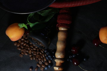 bowl with tobacco for hookah. fruits on a black background. smoke hookah