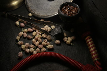 Fototapeta na wymiar bowl with tobacco for hookah. fruits and berries on a black background. smoke hookah