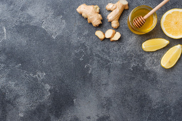 Lemon honey and ginger root on dark grey background with copy space. Ingredients for a tonic...