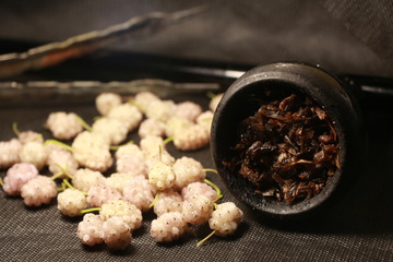 bowl with tobacco for hookah. fruits on a black background