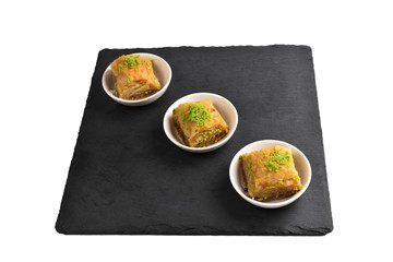 Pistachio baklava on a black plate. Dessert.