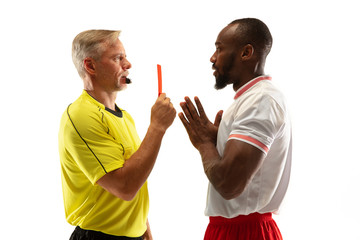 Referee showing a red card to a displeased african-american football or soccer player while gaming...
