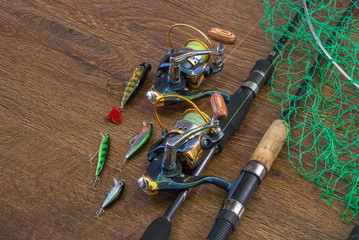 Fishing tackle - fishing spinning, hooks and lures on darken wooden background