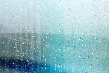 summer rain wet glass / abstract background landscape on a rainy day outside the window blurred background