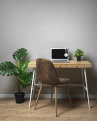 Wooden desk with chair and grey laptop
